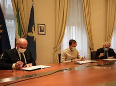 La firma della lettera d’intenti: da sinistra Dipiazza, Fedriga e Fantoni. L'ex sottostazione elettrica: sarà il quartier generale del nuovo istituto. Foto Lasorte