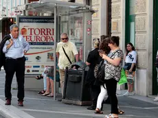 Persone in strada a Trieste, qualcuno con la mascherina al collo