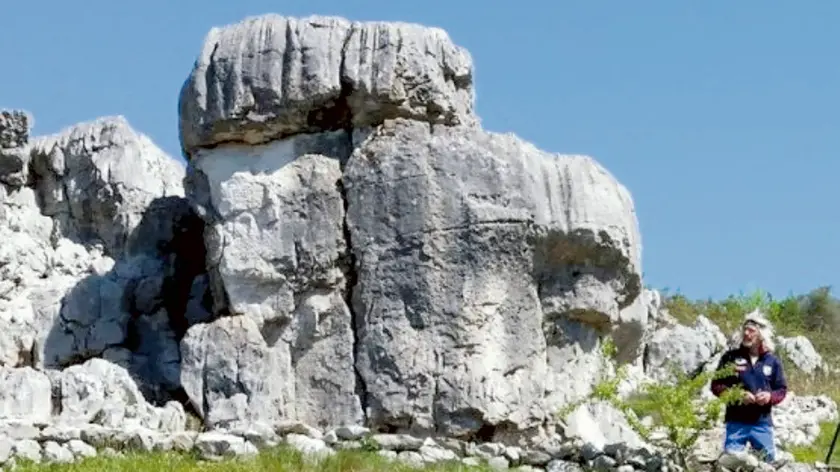 Il masso chiamato Sass de San Belin sulle alture di Polazzo e in basso a destra Luciano Visintin detto Cianela che ha costruito il sentiero di accesso e sistemato l’area circostante