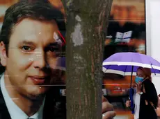 A woman wearing a face mask to protect against coronavirus walks past a poster of Serbia's President Aleksandar Vucic in Belgrade, Serbia, Friday, July 17, 2020. Serbia's president says he hopes the Balkan country will have a vaccine for the coronavirus for use by the end of this year, in cooperation with an unspecified foreign country. (AP Photo/Darko Vojinovic)