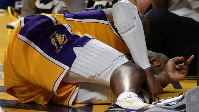 epa03660188 Kobe Bryant of the Los Angeles Lakers lies on the court in pain during the game against the Golden State Warriors in the second half during their NBA game at the Staples Center in Los Angeles, California, USA, 12 April 2013. Bryant later left the game and the Lakers won the game. EPA/MICHAEL NELSON CORBIS OUT