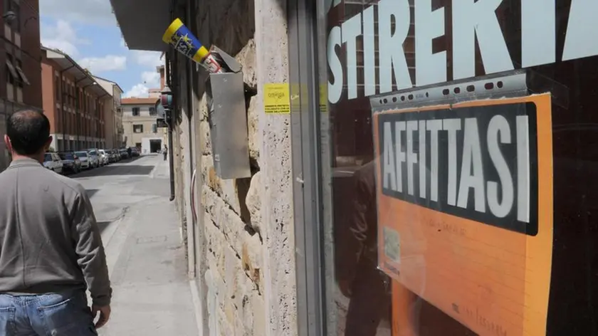Il cartello ''AFFITTASI'' sulla saracinesca abbassata di un negozio chiuso a Pisa, 8 maggio 2012. ANSA / FRANCO SILVI