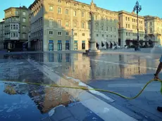 La pulizia di piazza Unità al mattino