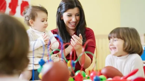 Bambini giocano con la maestra in un asilo nido