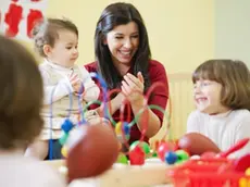 Bambini giocano con la maestra in un asilo nido