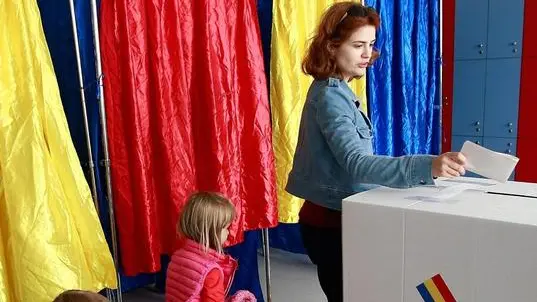 epa07077032 A woman is followed by her daughters while casting her ballot during the family re-definition referendum at a polling station in Bucharest, Romania, 07 October 2018. Romanians are going to polls on 06 and 07 October to vote on proposed constitutional changes, with Romania not currently recognizing same-sex couples. EPA/Bogdan Cristel