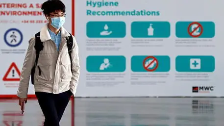 epa08200395 A worker using a mask leaves the Mobile World Congress' facilities in Barcelona, Spain, 07 February 2020. Ericsson and LG announced that they will not attend the Mobile World Congress due to coronavirus. The Congress will run from 24 to 27 February. EPA/Toni Albir