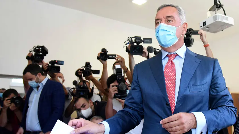 Montenegrin President Milo Djukanovic wearing a mask against the spread of the new coronavirus casts his ballot to vote in parliamentary elections at a polling station in Podgorica, Montenegro, Sunday, Aug. 30, 2020. Voters in Montenegro on Sunday cast ballots in a tense election that is pitting the long-ruling pro-Western party against the opposition seeking closer ties with Serbia and Russia. The parliamentary vote is marked by a dispute over a law on religious rights that is staunchly opposed by the influential Serbian Orthodox Church. (AP Photo/Risto Bozovic)