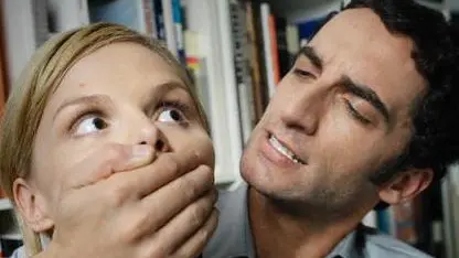 Man Covering Woman's Mouth --- Image by © Bernd Vogel/Corbis