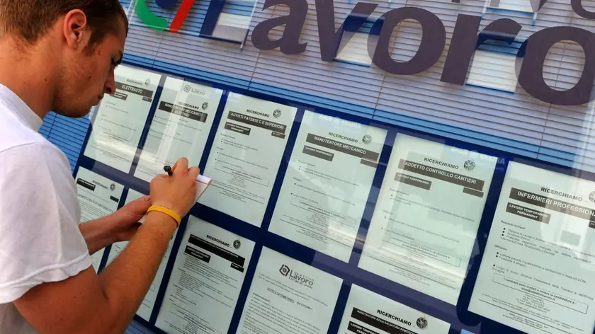 Un giovane consulta annunci in cerca di lavoro