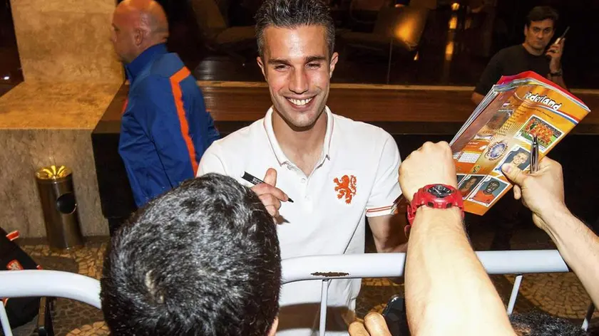 epa04255383 Dutch national soccer team player Robin van Persie signs autographs as he arrives at the Ceasar Park Ipanema hotel after the FIFA World Cup 2014 group B preliminary round match against Spain, in Rio de Janeiro, Brazil, 14 June 2014. The Dutch national soccer team will stay at the Cesar Park Ipanema hotel during the FIFA World Cup 2014. EPA/JASPER RUHE