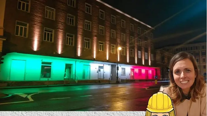 L'Urban Center di Trieste illuiminato con il tricolore nella foto postata su Fb dall'assessore Elisa Lodi che la vede ritratta sulla destra
