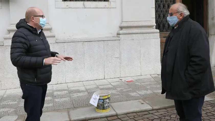 Il residente Braidot consegna il secchio al sindaco (Foto Bumbaca)
