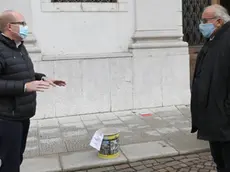 Il residente Braidot consegna il secchio al sindaco (Foto Bumbaca)
