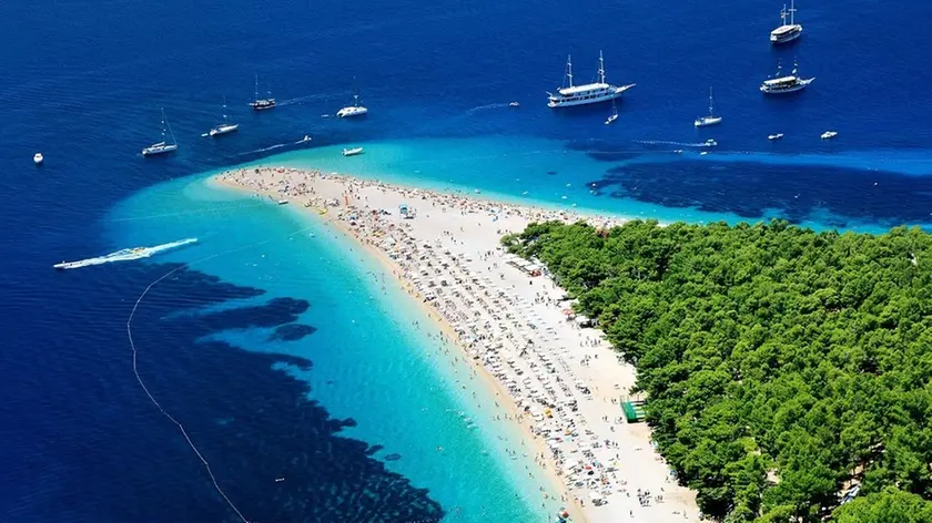 La più bella spiaggia di Brazza, lo Zlatni Rat pieno di turisti, un’immagine che oramai resterà un ricordo