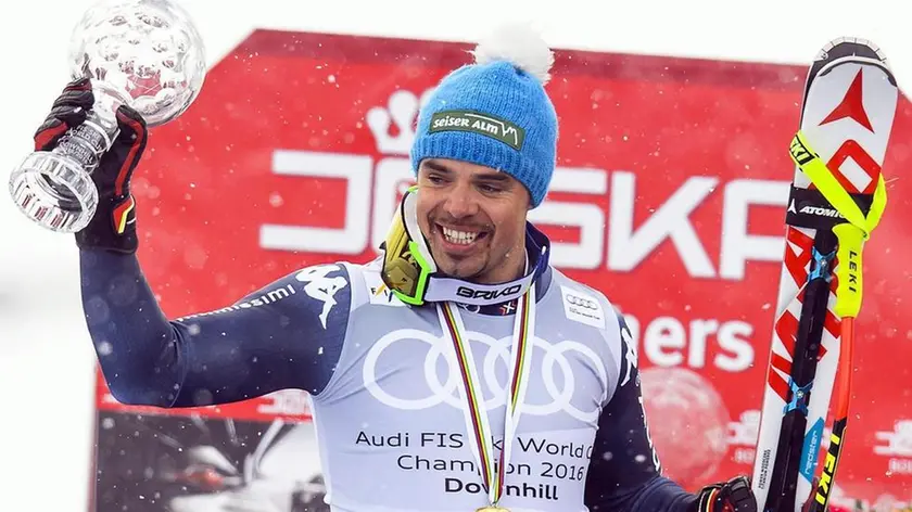 epa05214247 Peter Fill of Italy celebrates with the crystal globe after taking the overall Downhill World Cup title following the men's Downhill race at the FIS Alpine Skiiing World Cup Finals in St. Moritz, Switzerland, 16 March 2016. EPA/JEAN-CHRISTOPHE BOTT