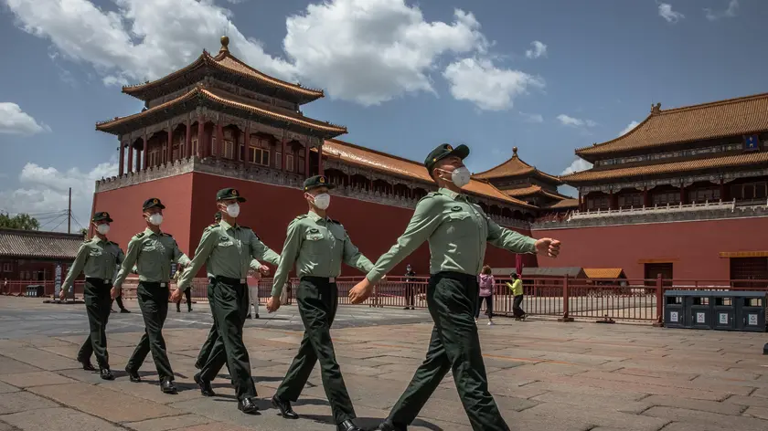 epa08428938 Chinese People's Liberation Army (PLA) soldiers wearing protective face masks march past the entrance to the Forbidden City, in Beijing, China, 18 May 2020. China will hold the Chinese People's Political Consultative Conference (CPPCC) on 21 May and the National People's Congress (NPC) on 22 May after the two major political meetings initially planned to be held in March 2020 were postponed amid the coronavirus outbreak. EPA/ROMAN PILIPEY