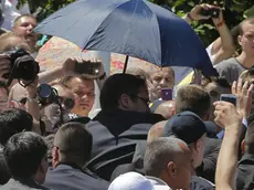 Le guardie del corpo aprono un ombrello a protezione del premier serbo