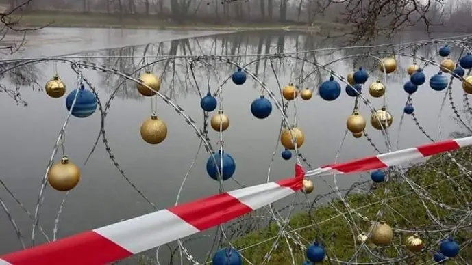 Qualcuno non ha perso lo humor e ha "addobbato" il filo spinato per Natale