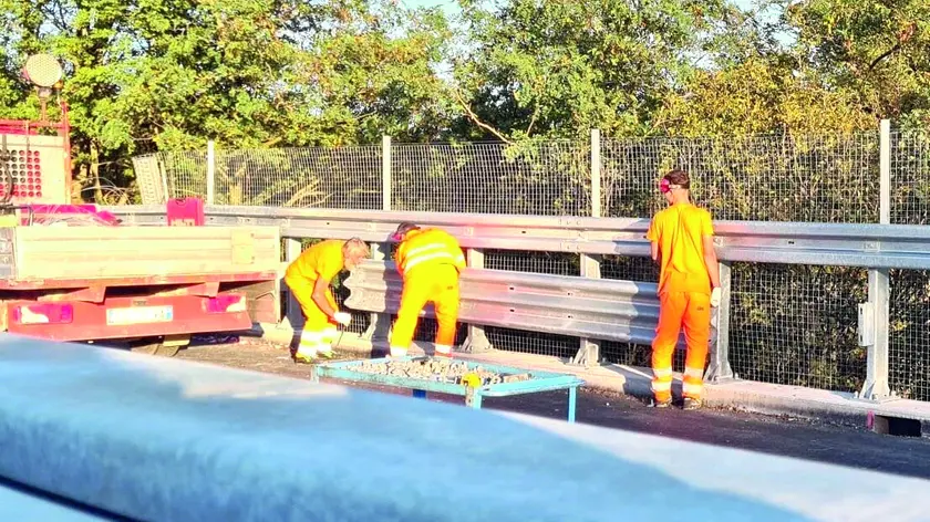 Operai al lavoro lungo il nuovo cavalcavia prima della riapertura