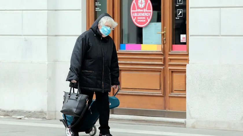 Una signora a passeggio con la mascherina