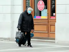 Una signora a passeggio con la mascherina