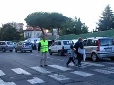 Un nonno-vigile davanti a una scuola