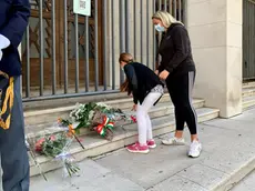 Una bambina, accompagnata dalla mamma, depone un mazzo di fiori davanti alla Questura nella mattinata di oggi, domenica 4 ottobre, primo anniversario della tragedia (Foto Massimo Silvano)