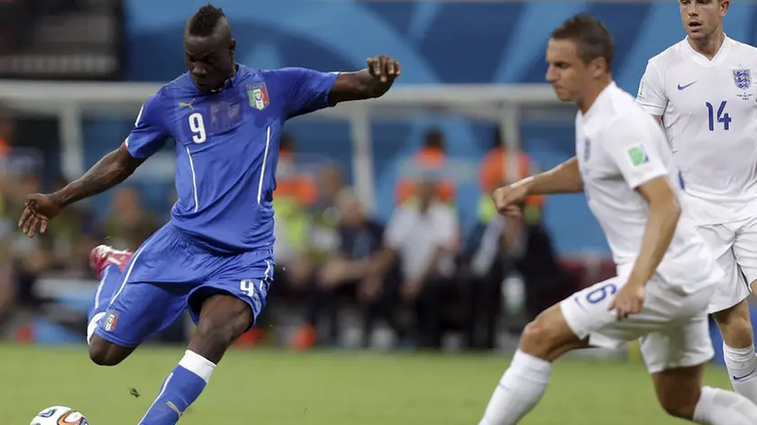 Italy's Mario Balotelli, left, gets in a shot as England's Phil Jagielka, center, and Jordan Henderson, right, defend during the group D World Cup soccer match between England and Italy at the Arena da Amazonia in Manaus, Brazil, Saturday, June 14, 2014. (AP Photo/Martin Mejia)
