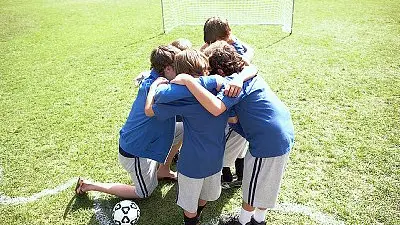 Boys soccer team in a huddle --- Image by © Pauline St. Denis/Corbis