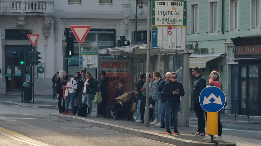 Persone in attesa alla fermata del bus a Trieste (Lasorte)