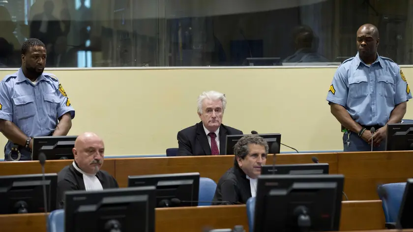 epa07450646 Former Bosnian Serb leader Radovan Karadzic (C, rear) sits in the court room of the International Residual Mechanism for Criminal Tribunals in The Hague, Netherlands, 20 March 2019. Nearly a quarter of a century since Bosnia's devastating war ended, Karadzic is set to hear the final judgment on whether he can be held criminally responsible for unleashing a wave of murder and destruction. United Nations appeals judges will on Wednesday rule whether to uphold or overturn Karadzic's 2016 convictions for genocide, crimes against humanity and war crimes, as well as his 40-year sentence. EPA/PPETER DEJONG