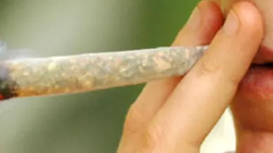 Un ragazzo mentre fuma una sigaretta di marijuana (foto da Internet)