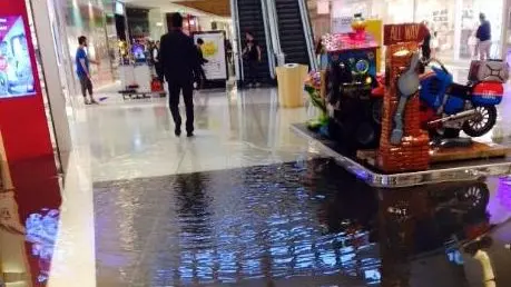 Un corridoio di Tiare Shopping allagato dall’acqua piovana