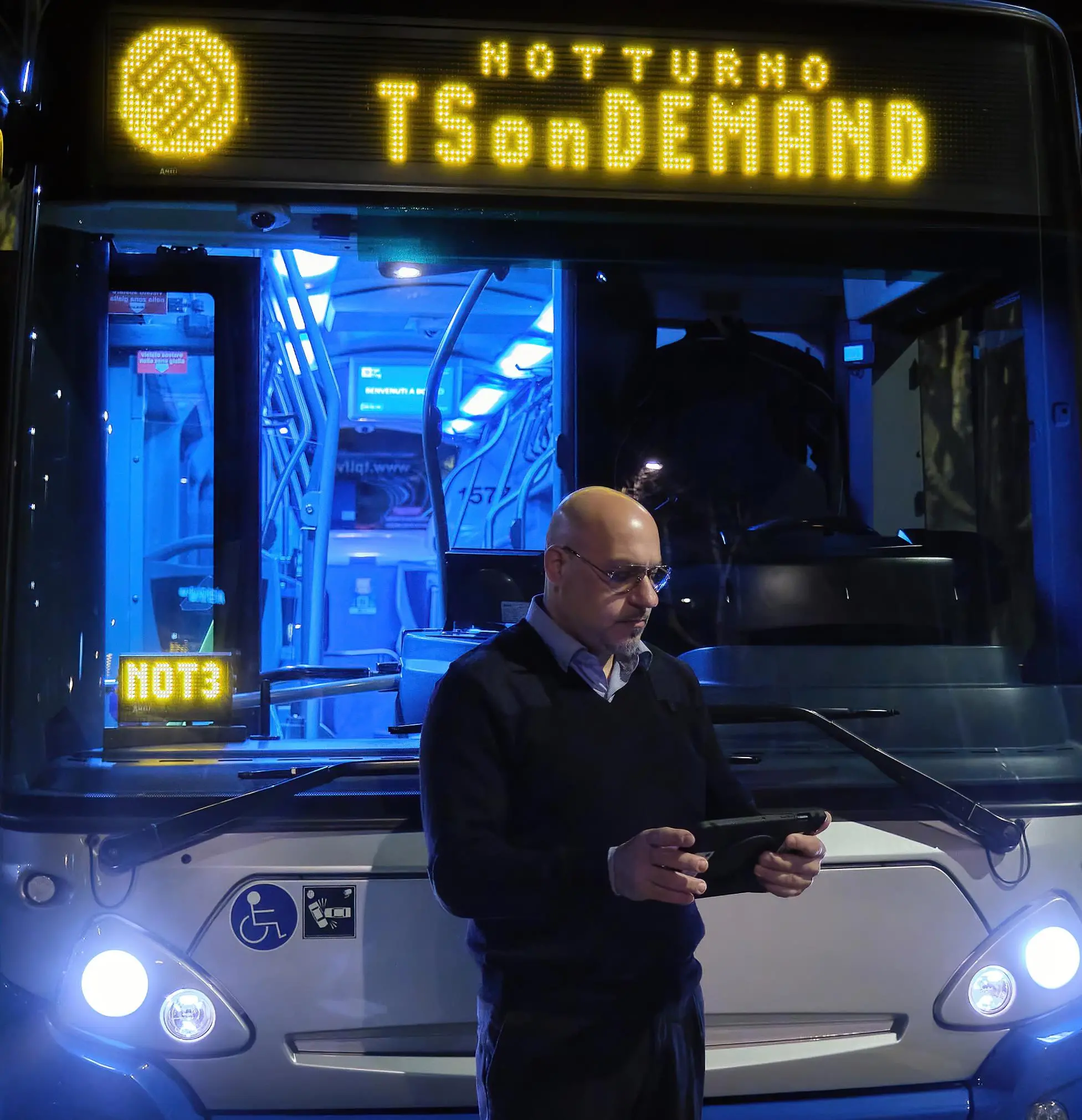 Un conducente consulta le prenotazioni davanti al bus notturno Foto Silvano