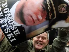 epa03473090 A man holds a poster showing a portrait of general Ante Gotowina with a slogan: 'Croatian Pride' as Croatians react on the The Hague judgment the International War Crimes Tribunal for the former Yugoslavia (ICTY) of deliberating Croatian generals Ante Gotovina and Mladen Markac, as they watch a courtroom broadcast on a screen in downtown Zagreb, 16 November 2012. The appeals chamber of the ICTY on 16 November overturned guilty verdicts against Croatian generals Ante Gotovina and Mladen Markac. The generals, who had been sentenced by the ICTY to 24 and 18 years respectively on charges of war crimes and crimes against humanity, were to be released immediately. Croatia hailed the verdict and street celebrations erupted immediately after it was read. EPA/ANTONIO BAT