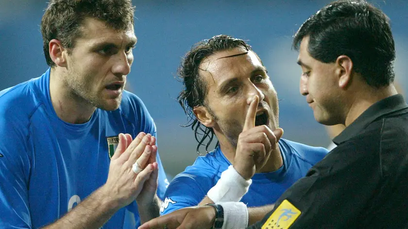 Italy's Angelo Di Livio (C) and Christian Vieri (L) protest as referee Byron Moreno (R) of Ecuador holds both yellow and red cards after he sent Italy's Francesco Totti off in extra time against South Korea during a second round World Cup Finals match in Taejon, June 18, 2002. REUTERS/Desmond Boylan