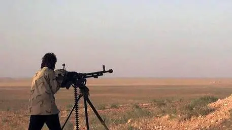 In this picture released on Wednesday, May 20, 2015 by the website of Islamic State militants, an Islamic State fighter aims his weapon during a battle against the Syrian government forces on a road between Homs and Palmyra, Syria. Islamic State militants overran the famed archaeological site at Palmyra early on Thursday, just hours after seizing the central Syrian town, activists and officials said, raising concerns the extremists might destroy some of the priceless ruins as they have done in neighboring Iraq. (The website of Islamic State militants via AP)