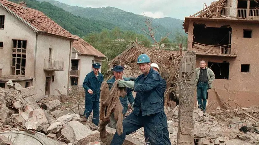 BEL18-28041999-SURDULICA; YUGOSLAVIA-: A member of a rescue team holds a sweater, as he and his colleagues search the rubble of destroyed houses, Wednesday 28 April 1999 in Surdulica, some 250 km south of Belgrade, after the village was hit during a NATO air raid on Tuesday. At least 20 civilians were killed and many injured, when NATO aimed to hit army barracks in Surdulica. EPA PHOTO/VLADIMIR VETKIN/as