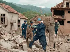 BEL18-28041999-SURDULICA; YUGOSLAVIA-: A member of a rescue team holds a sweater, as he and his colleagues search the rubble of destroyed houses, Wednesday 28 April 1999 in Surdulica, some 250 km south of Belgrade, after the village was hit during a NATO air raid on Tuesday. At least 20 civilians were killed and many injured, when NATO aimed to hit army barracks in Surdulica. EPA PHOTO/VLADIMIR VETKIN/as