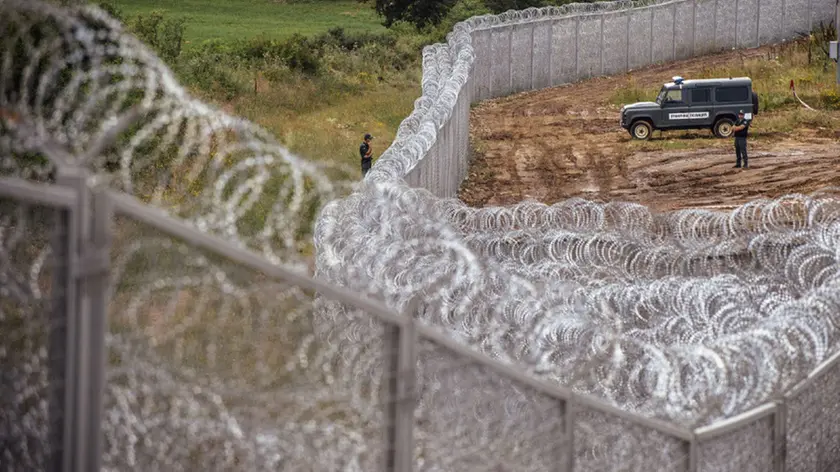 Border policemen stand guard next to a barbed wire wall on the Bulgarian border with Turkey, near the village of Golyam Dervent on July 17, 2014. Overwhelmed by an influx of mostly Syrian immigrants, Bulgaria has taken steps to secure its EU border -- including building a barbed-wire fence -- but now faces criticism from rights groups. The 30-kilometre (19-mile) fence, standing three metres (10 feet) high and fortified with razor wire coils, was completed this week. Covering the least visible section of Bulgaria's 275-kilometre (170-mile) border with Turkey, it aims to stem a flow of refugees that saw more than 11,000 people enter the country illegally last year -- 10 times the annual figure before the Syrian conflict. AFP PHOTO / DIMITAR DILKOFFDIMITAR DILKOFF/AFP/Getty Images