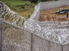 Border policemen stand guard next to a barbed wire wall on the Bulgarian border with Turkey, near the village of Golyam Dervent on July 17, 2014. Overwhelmed by an influx of mostly Syrian immigrants, Bulgaria has taken steps to secure its EU border -- including building a barbed-wire fence -- but now faces criticism from rights groups. The 30-kilometre (19-mile) fence, standing three metres (10 feet) high and fortified with razor wire coils, was completed this week. Covering the least visible section of Bulgaria's 275-kilometre (170-mile) border with Turkey, it aims to stem a flow of refugees that saw more than 11,000 people enter the country illegally last year -- 10 times the annual figure before the Syrian conflict. AFP PHOTO / DIMITAR DILKOFFDIMITAR DILKOFF/AFP/Getty Images