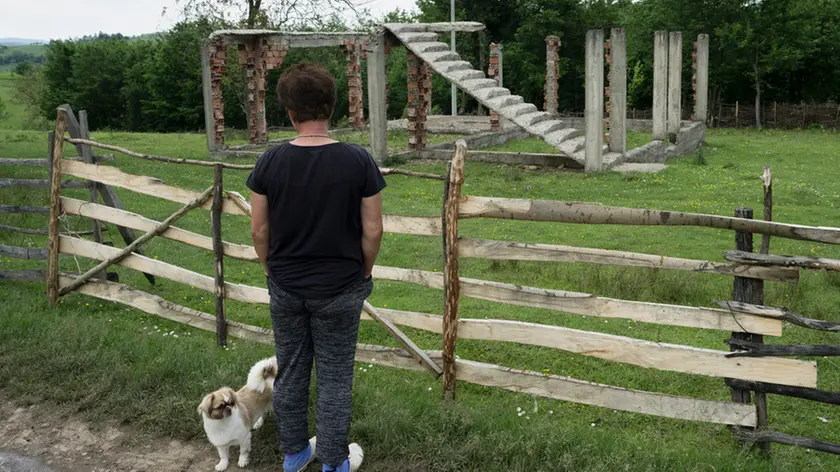 Davanti alle rovine di una casa in Bosnia (foto Ziyah Gafić - Amnesty)