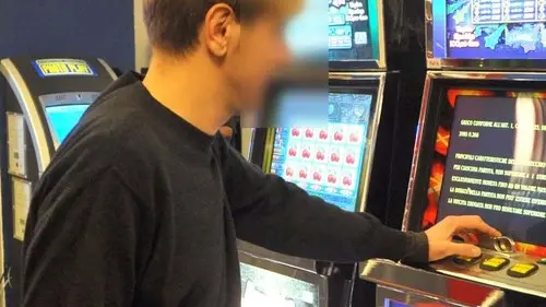 Un ragazzo davanti a una slot machine