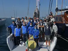 L'equipaggio di Venni Vind con la mascherina, sotto i ragazzi volontari dell’Istituto Nautico che si occupano degli ormeggi