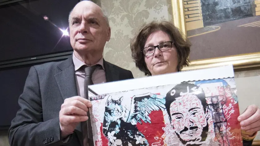 Claudio e Paola Regeni mostrano la foto di un murale fatto da writers egiziani su un muro di Berlino che raffigura il volto di Giulio Regeni con un gatto stilizzato durante la conferenza stampa all'interno della sala Nassiria a Palazzo Madama 4 aprile 2017 a Roma ANSA/MASSIMO PERCOSSI