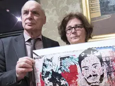 Claudio e Paola Regeni mostrano la foto di un murale fatto da writers egiziani su un muro di Berlino che raffigura il volto di Giulio Regeni con un gatto stilizzato durante la conferenza stampa all'interno della sala Nassiria a Palazzo Madama 4 aprile 2017 a Roma ANSA/MASSIMO PERCOSSI