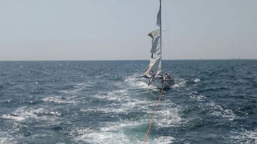 La vela rimasta bloccata a Porto Buso, trainata verso Grado dagli uomini di Circomare.