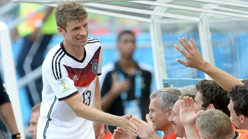 epa04261503 Germany's Thomas Mueller (C) is celebrated by teammates during the FIFA World Cup 2014 group G preliminary round match between Germany and Portugal at the Arena Fonte Nova in Salvador, Brazil, 16 June 2014. (RESTRICTIONS APPLY: Editorial Use Only, not used in association with any commercial entity - Images must not be used in any form of alert service or push service of any kind including via mobile alert services, downloads to mobile devices or MMS messaging - Images must appear as still images and must not emulate match action video footage - No alteration is made to, and no text or image is superimposed over, any published image which: (a) intentionally obscures or removes a sponsor identification image; or (b) adds or overlays the commercial identification of any third party which is not officially associated with the FIFA World Cup) EPA/ANDREAS GEBERT EDITORIAL USE ONLY