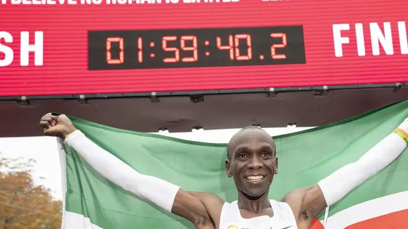 epaselect epa07914791 Eliud Kipchoge, Kenyan marathon world record holder, celebrates with the flag of Kenya in front of the finish line after the INEOS 1:59 Challenge in Vienna, Austria, 12 October 2019. Kipchoge attempted on the day to beat his own record becoming the first person to run a marathon distance under two hours, recording a time of 1 hour 59 minutes 40 seconds at the event. EPA/CHRISTIAN BRUNA EDITORIAL USE ONLY